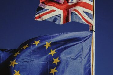 two flags flying next to each other on a pole